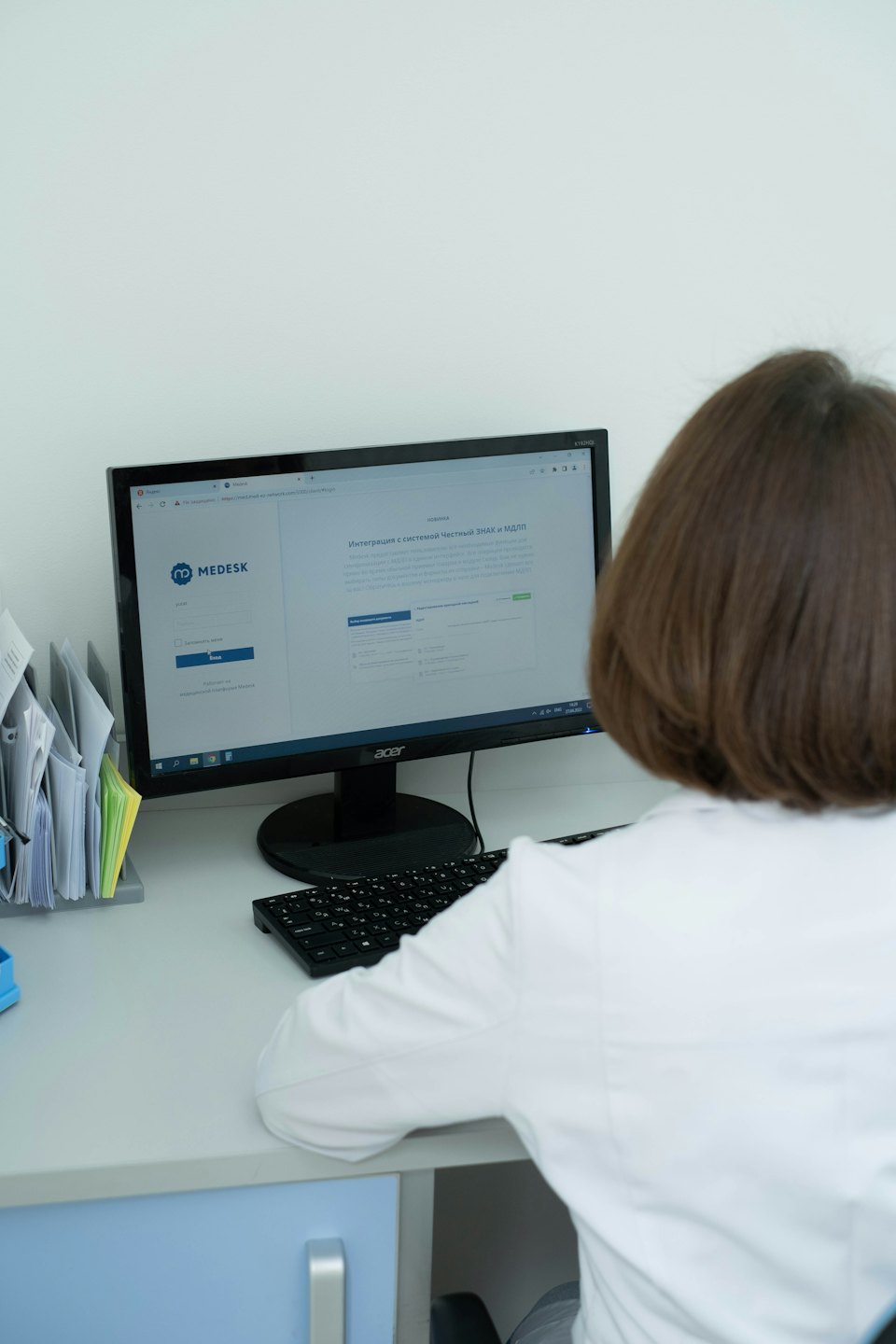 Professionista medico che usa un software al computer su una scrivania pulita.